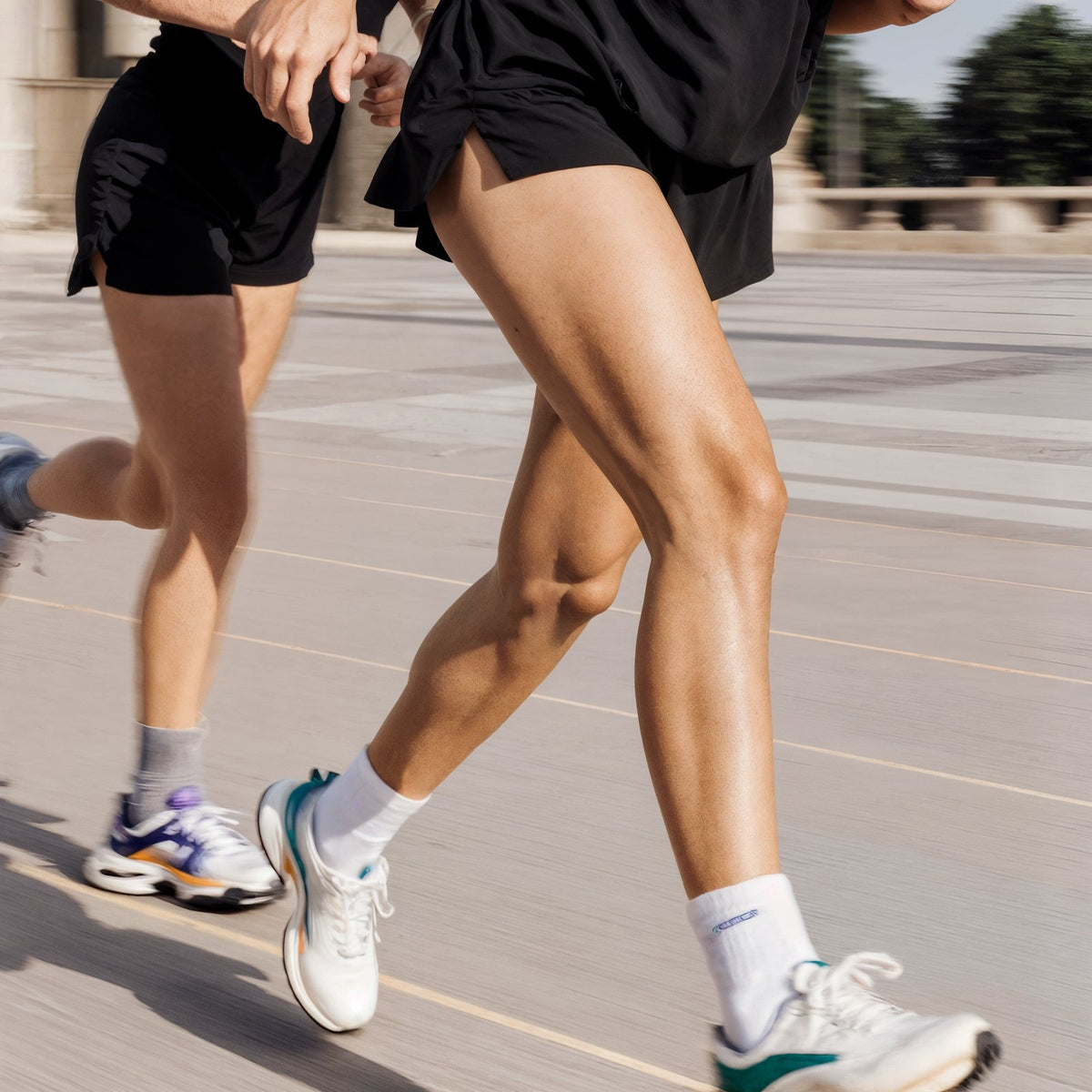 Two runners striding along an outdoor track